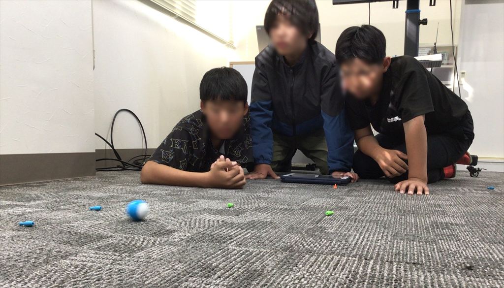 動いているスフィロを見守る児童たちの写真です。